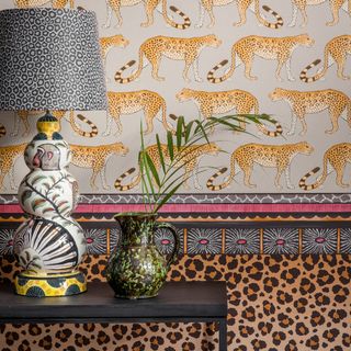 leopard designed wall with table lamp and green designed pot