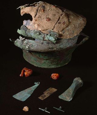 A bronze urn and bronze and amber items from the Lusehøj grave, where researchers found the bones of what they think is a Scandinavian man along with bits of "luxurious" fabric made from imported nettles.