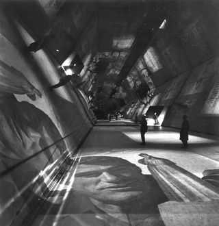 Black and white image of what seems to be a hexagonal tunnel with mirrored surfaces
