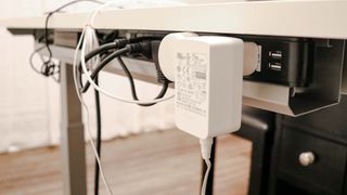 A cable management tray with a power strip with multiple devices plugged in