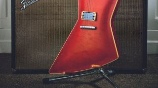 An red, Explorer style guitar on an offset guitar stand