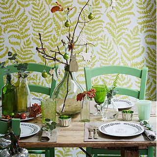 christmas dining room with green fern wallpaper green chairs and christmas decorations