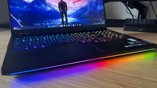 Close up on RGB light strip running underneath the top lip of the Lenovo Legion Pro 7i Gen 9 gaming laptop, reflecting onto a wooden desk