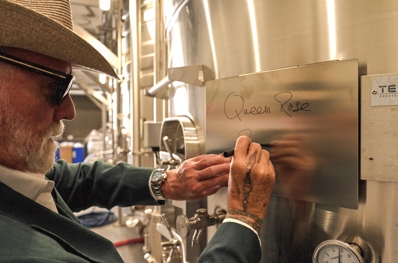 Roger Taylor signing wine tank in winery 