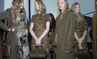 3 Models wearing combinations of gold and brown coats and dresses