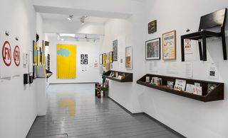 Posters, photographs, letters, diaries, videos and press cuttings as well as art works in a room.