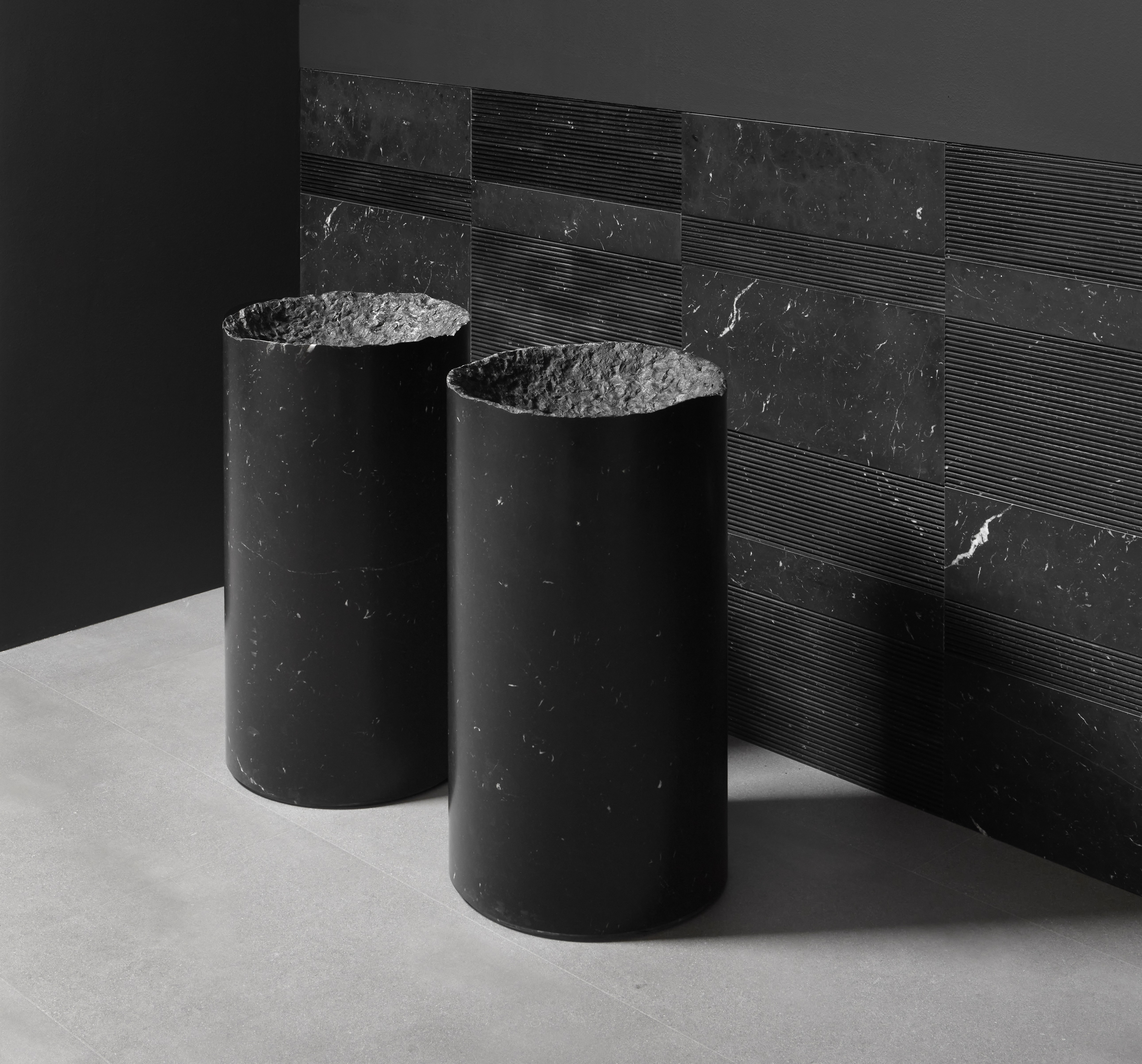 two black cylindrical freestanding washbasins 