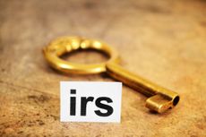Close up of a golden key with a notecard that says "IRS"