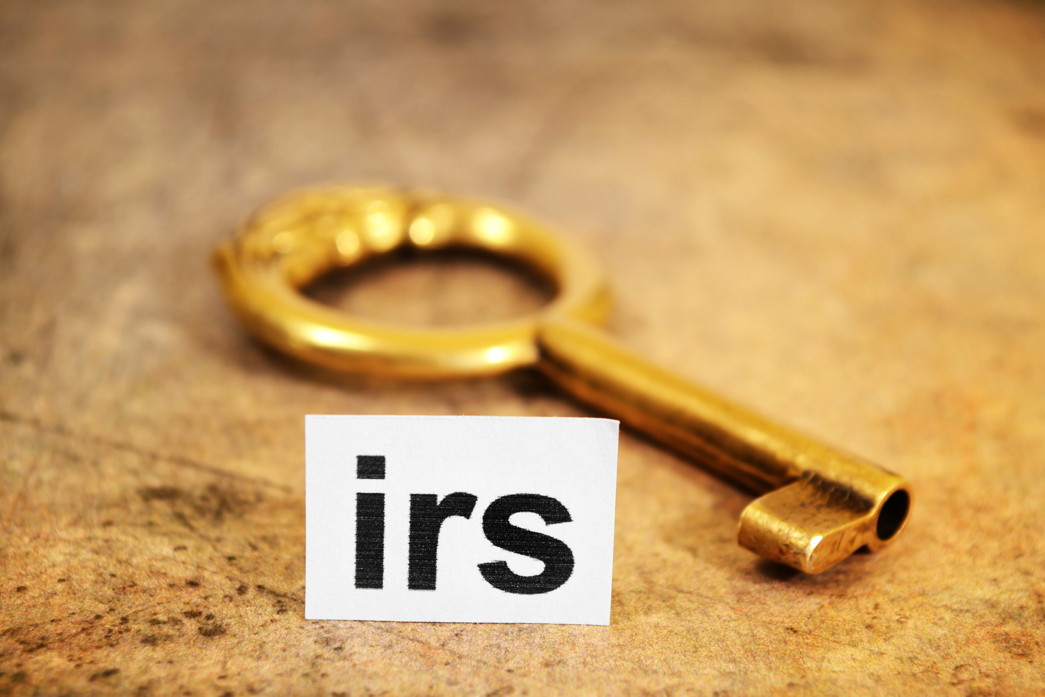 Close up of a golden key with a notecard that says "IRS"