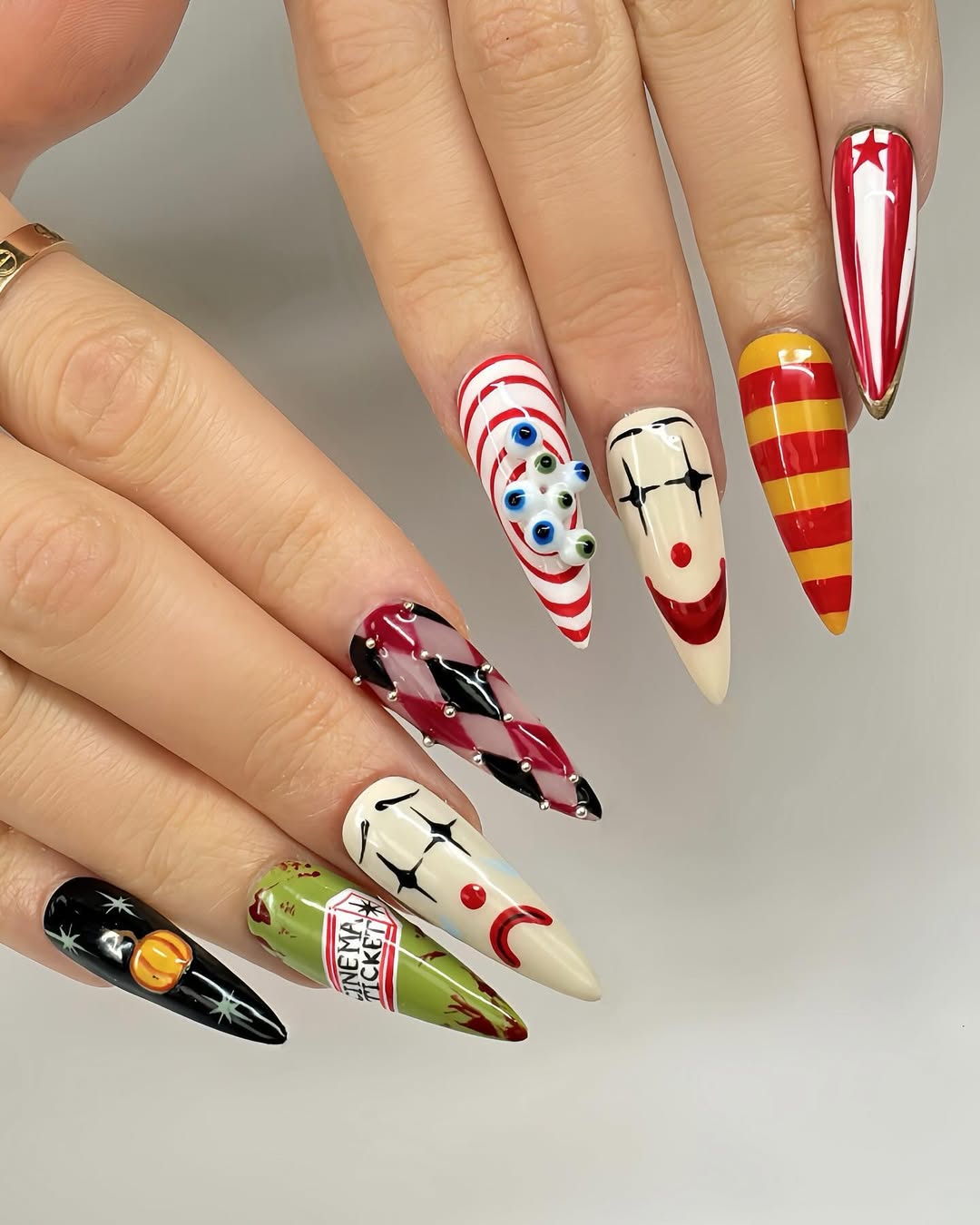 halloween manicure with scary clowns in red and tan