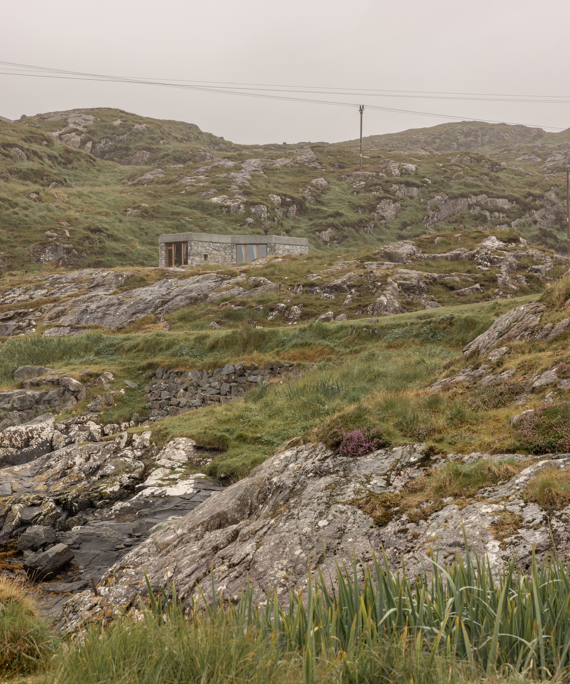 A single-storey stone house in a cliffside