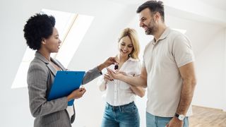 realtor with clients handing over keys