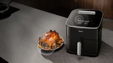 Typhur 8QT Sync Air Fryer with Built-in Wireless Meat Thermometer, next to a whole roast chicken