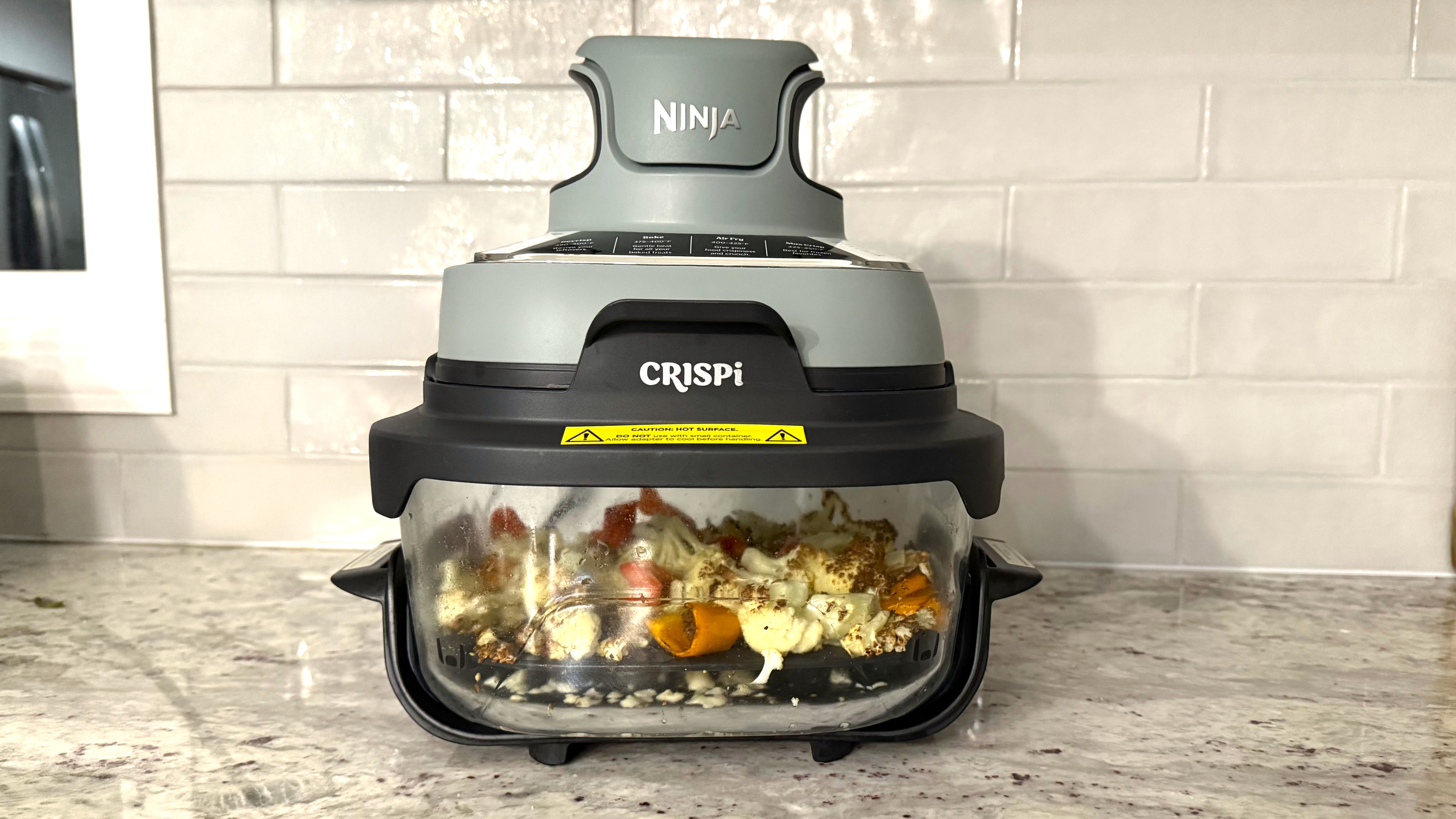 Ninja Crispi air fryer with food on kitchen counter