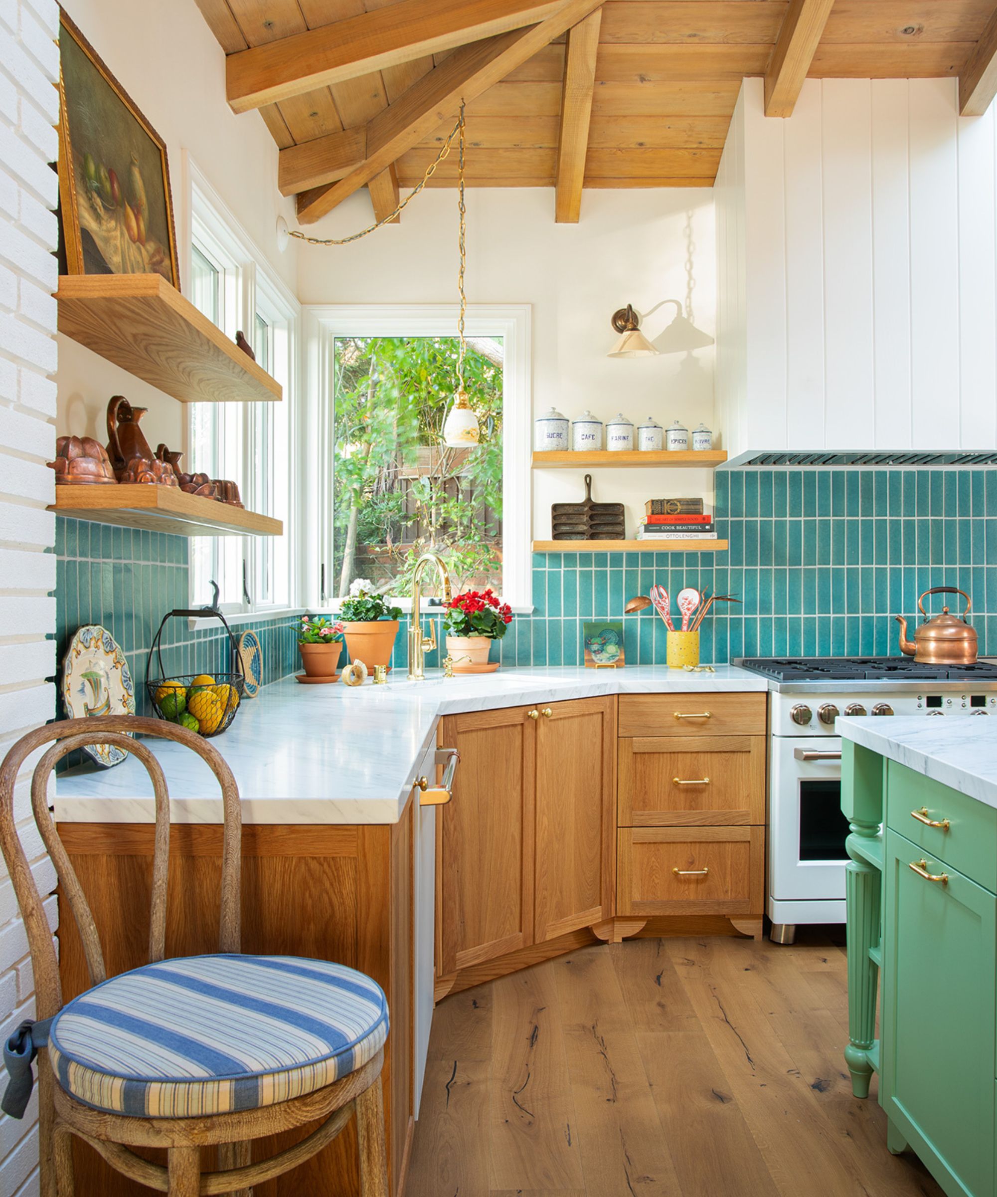 A ranch kitchen with wood paneled vaulted ceilings, wood cabinets, blue backsplash tiles, and a green island