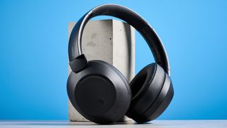 the mixx streamq c4 headphones in black with a blue background showing the soft cups and buttons controls