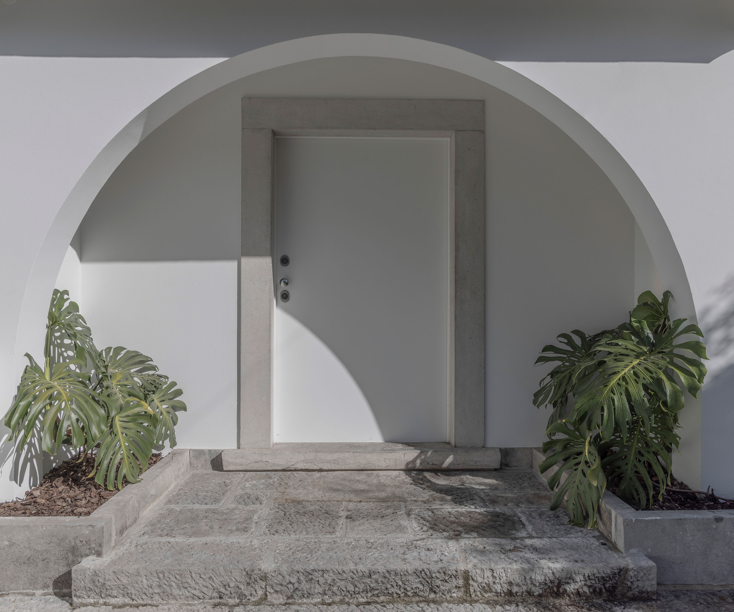 modern white arched porch with simple white front door