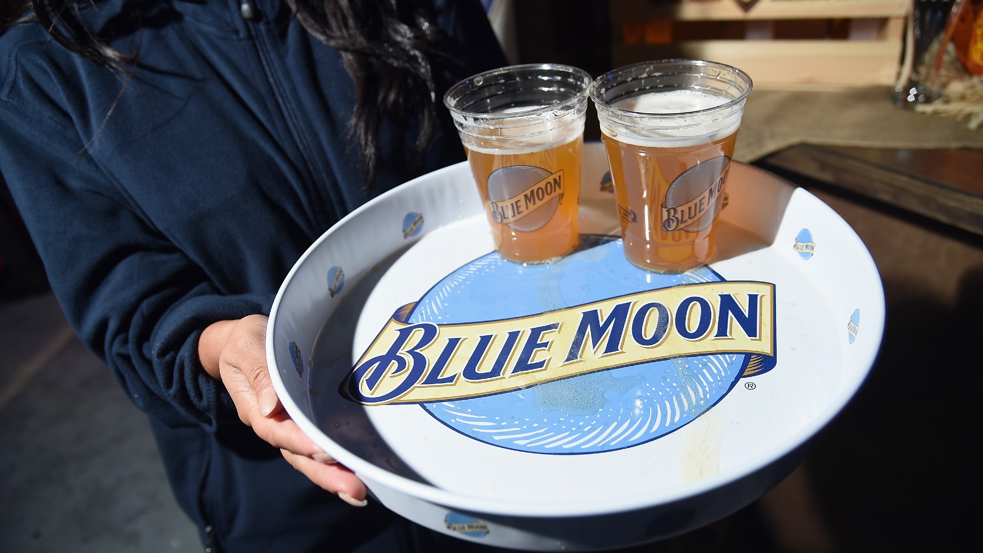 a tray of cups of beer sporting the words 'blue moon' over a blue orb