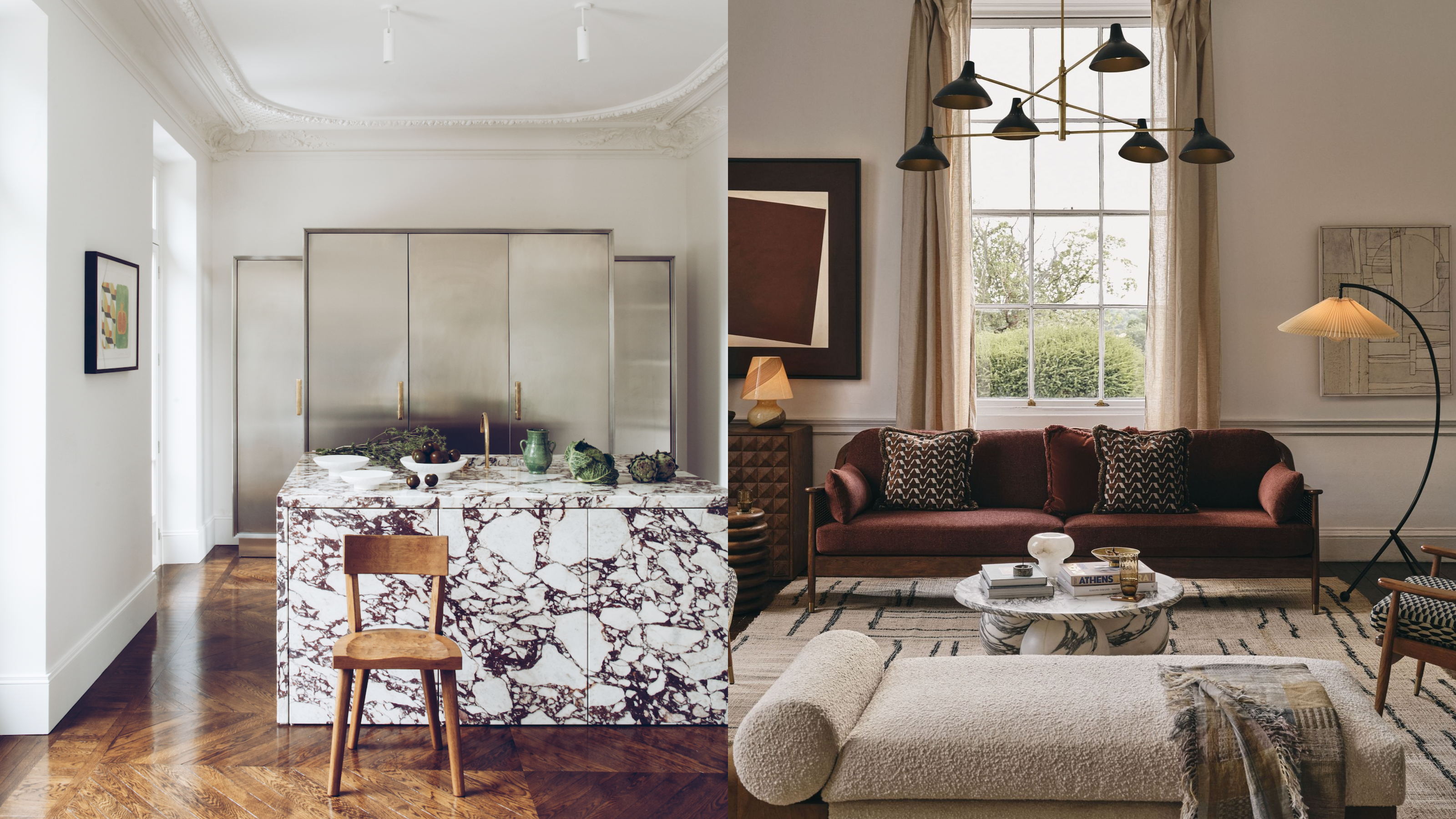 A kitchen with a heavily veined marble island and white walls and a warmly lit living room