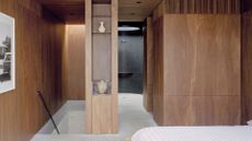 A spacious bedroom with a wood closet and a path to the bathroom