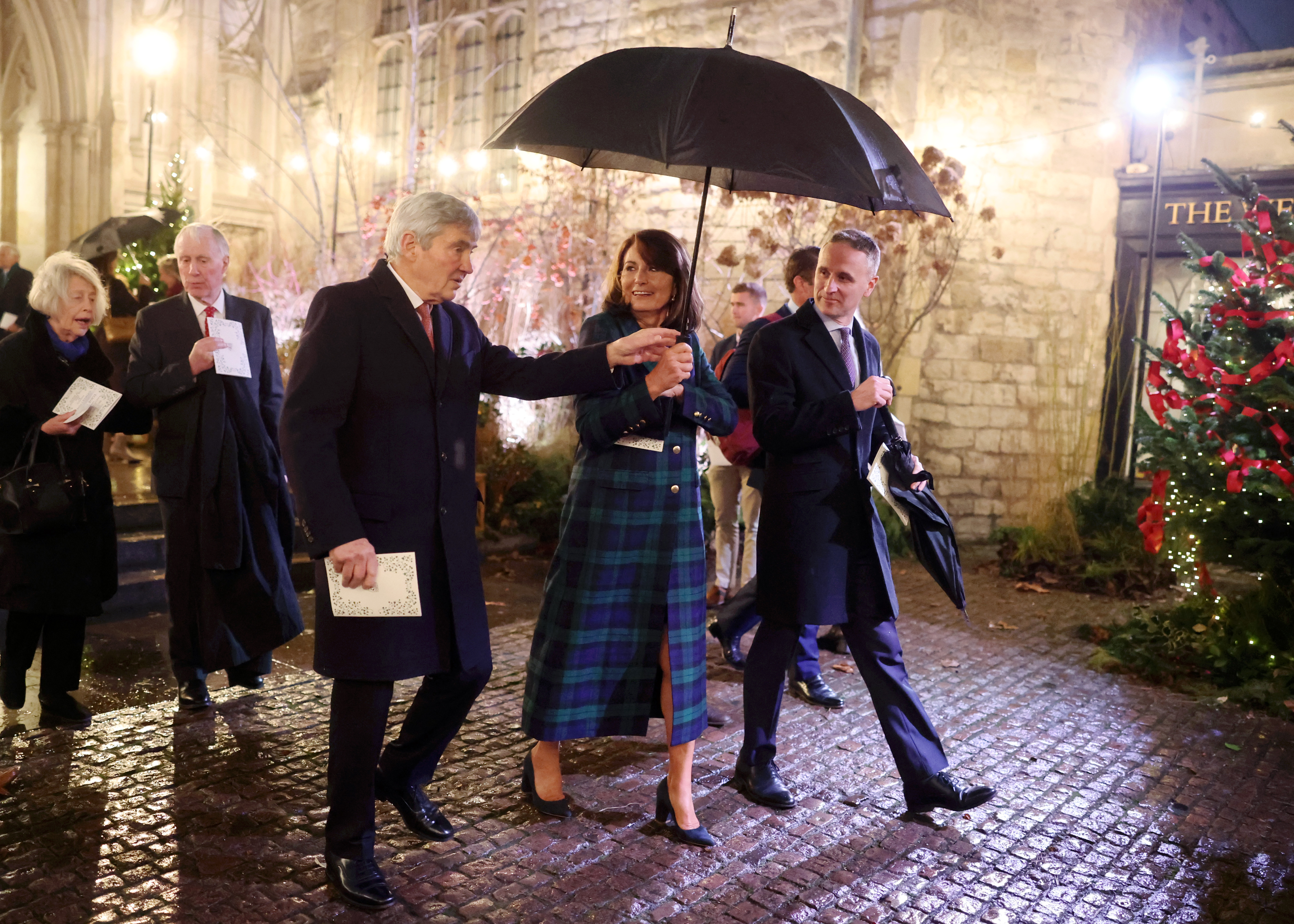 Carole Middleton and Michael Middleton walking with an umbrella outside Westminster Abbey at the Together at Christmas concert