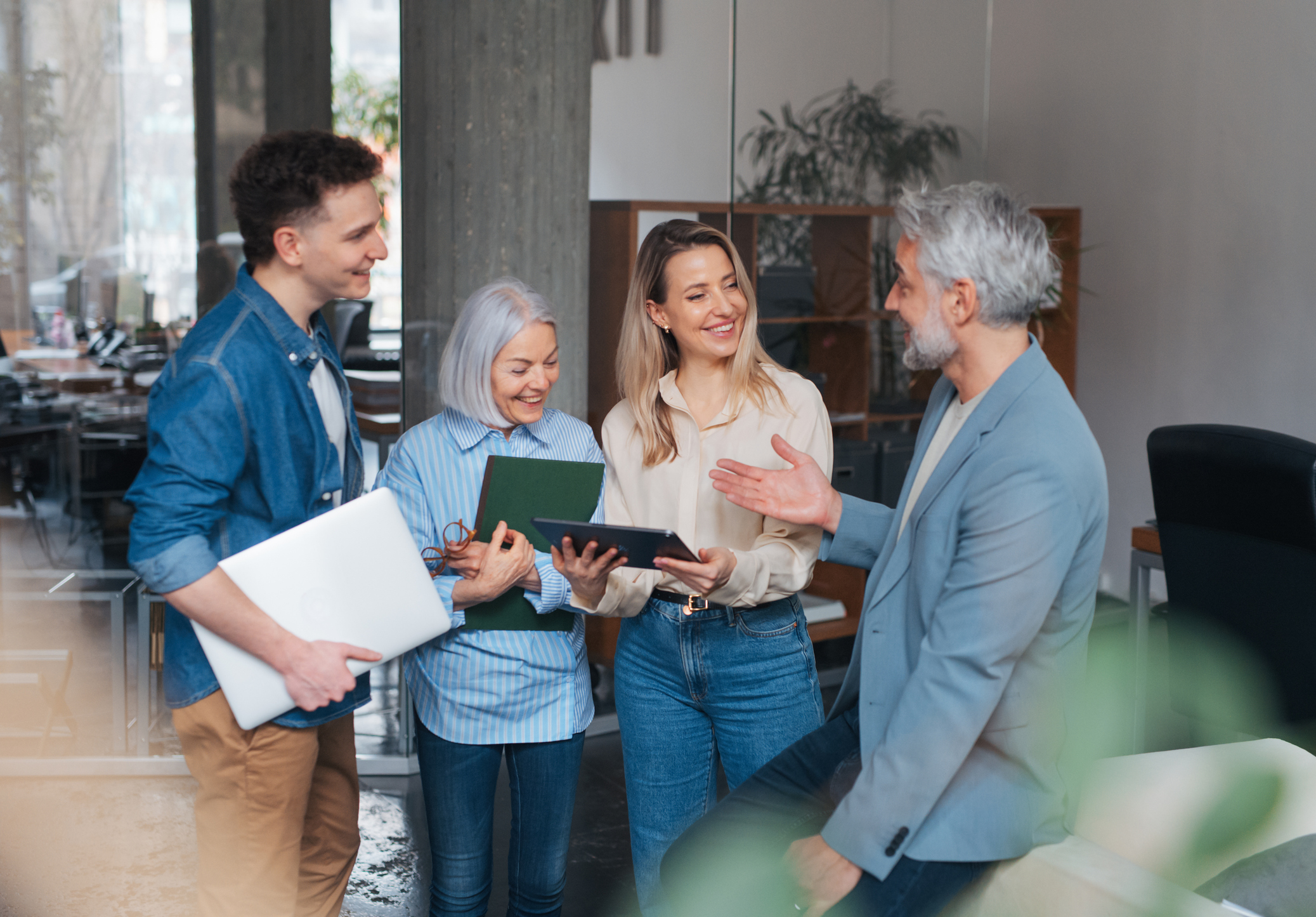 Age diverse team in a business meeting. Colleagues and manager in various age groups having casual discussion during meeting, workshop in office