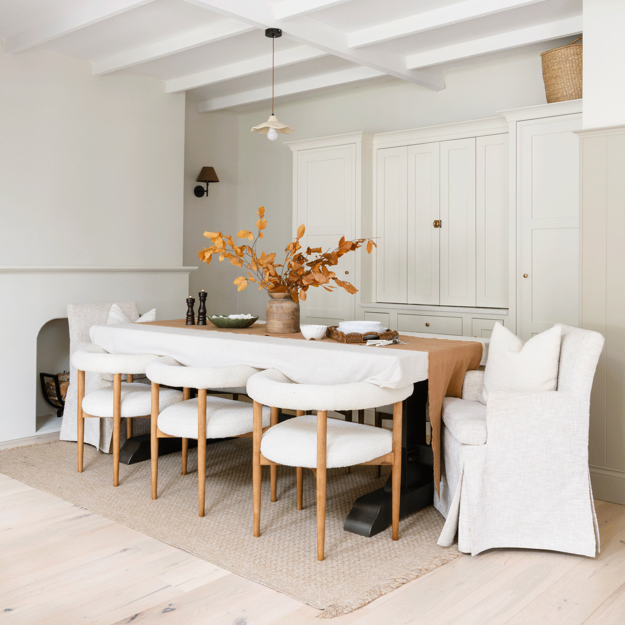 the dining area in an open plan kitchen diner with upholstered dining chairs and a large storage cabinet