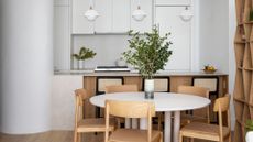 A minimal dining room with white walls and earthy wooden accents