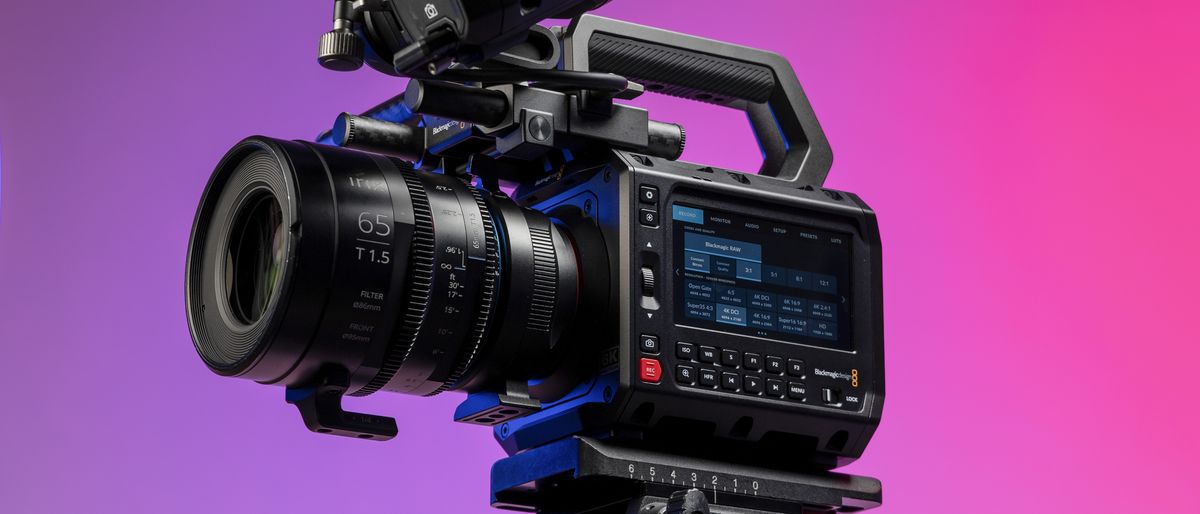 Blackmagic Pyxis 6K camera in the studio, mounted to video tripod, with a vibrant magenta background