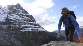  Hardshell vs softshell: man hiking next to snowy mountain