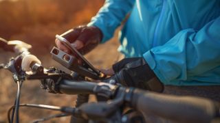 Trail rider using their phone, within one of the best bike phone mounts