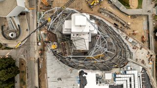 aerial photo of a white building surrounded by metallic scaffolding