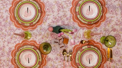 Ro'Table table setting featuring scalloped placemats, a floral tablecloth, and vintage-inspired palm-motif plates
