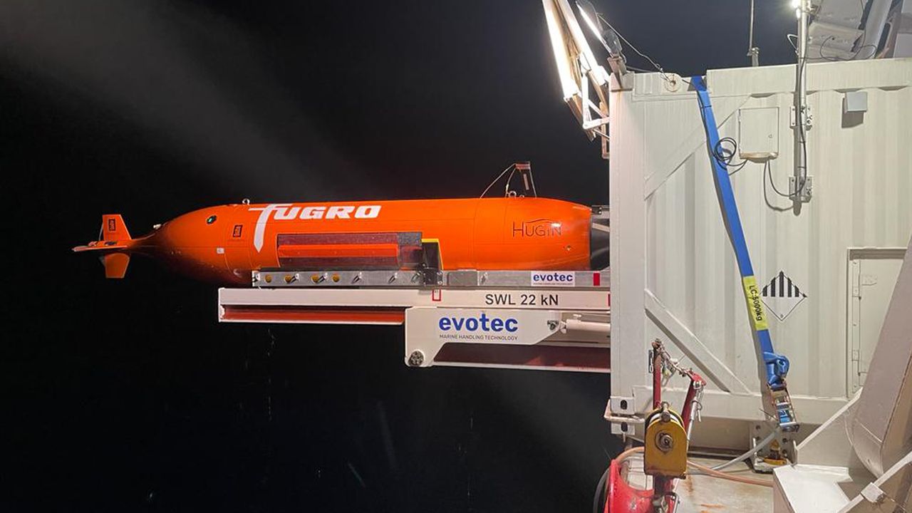 A red torpedo-shaped autonomous underwater vehicle.