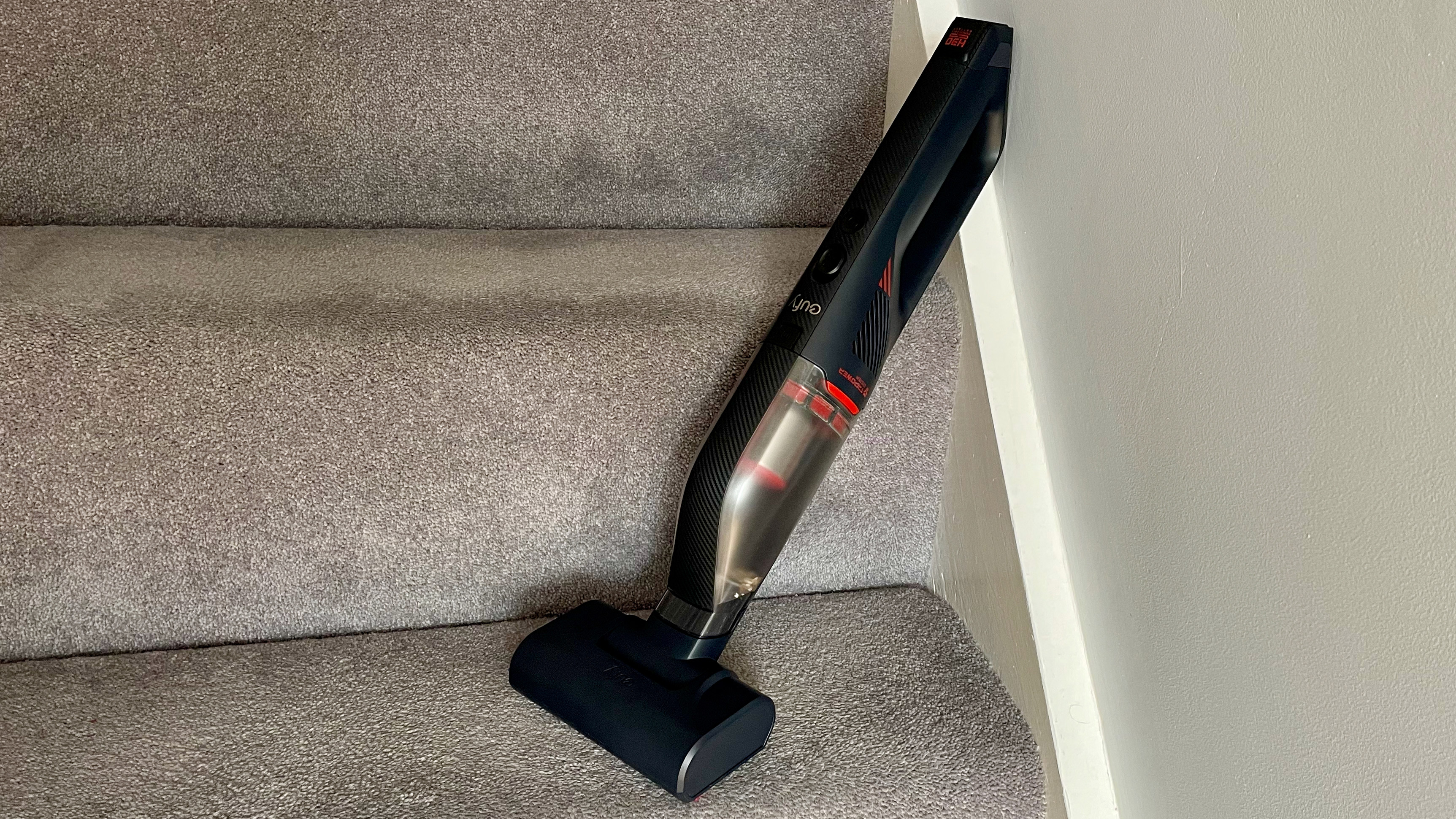 The Eufy HomeVac H30 Mate leaning up against a wall on a staircase