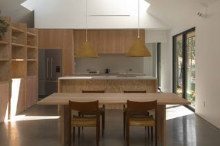 Dining area and kitchen with high ceiing and skylight