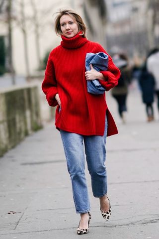 a woman wearing straight leg jeans with a red jumper