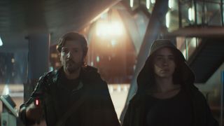 Cassian and a hooded Bix walking down a street in Andor season 2