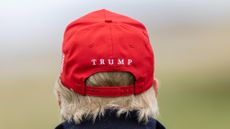 back of Trump's head with red cap reading "Trump"