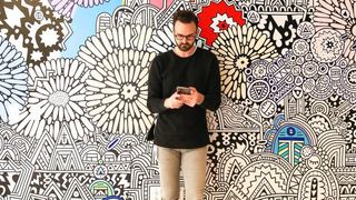 Man using phone against a colourful patterned background
