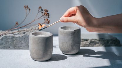 Affordable candles - person lighting a grey candle