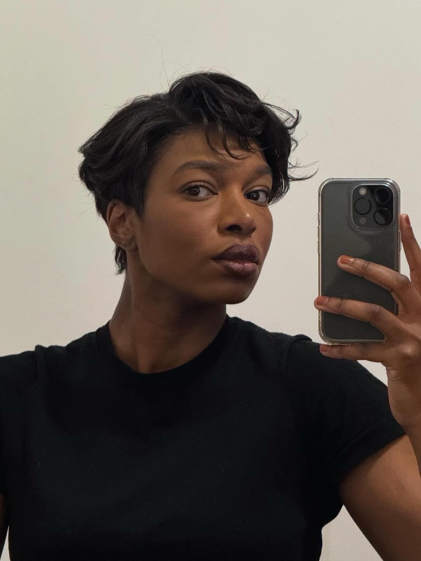 Influencer @thevisuelofgrace taking a mirror selfie with a tucked pixie hairstyle