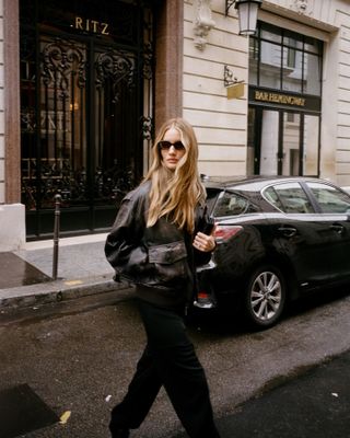 Rosie Huntington-Whitely with long hair wearing sunglasses and a leather jacket