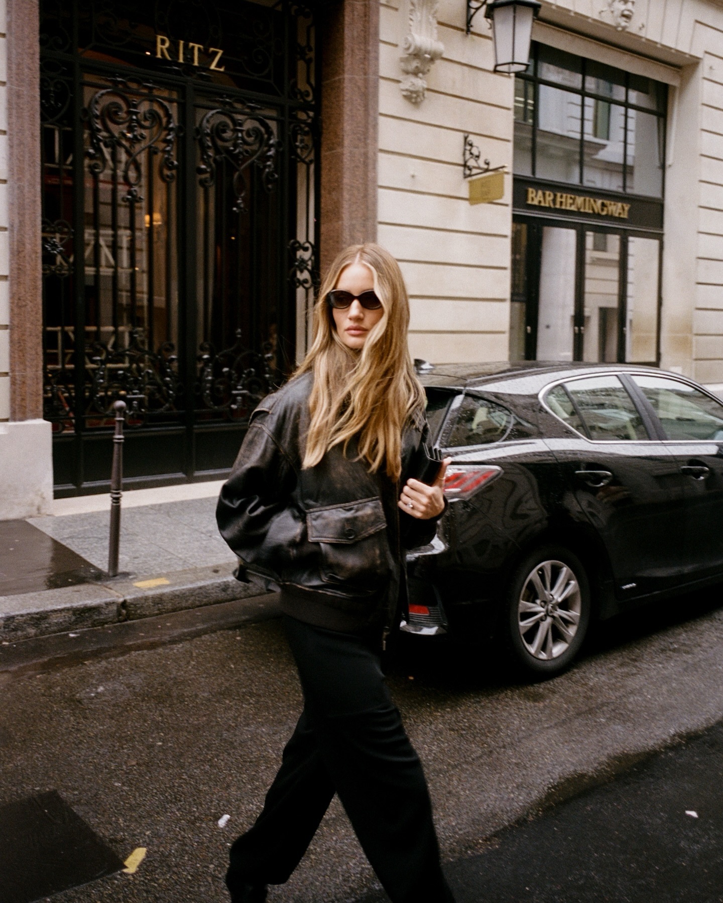 Rosie Huntington-Whitely with long hair wearing sunglasses and a leather jacket