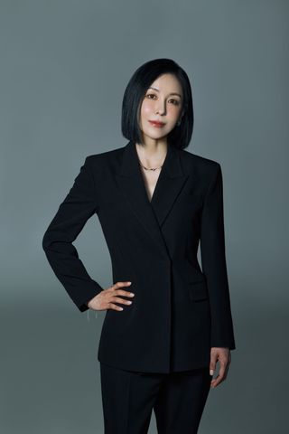 Hee Jun Yoon stands facing the camera with her right hand on her hip