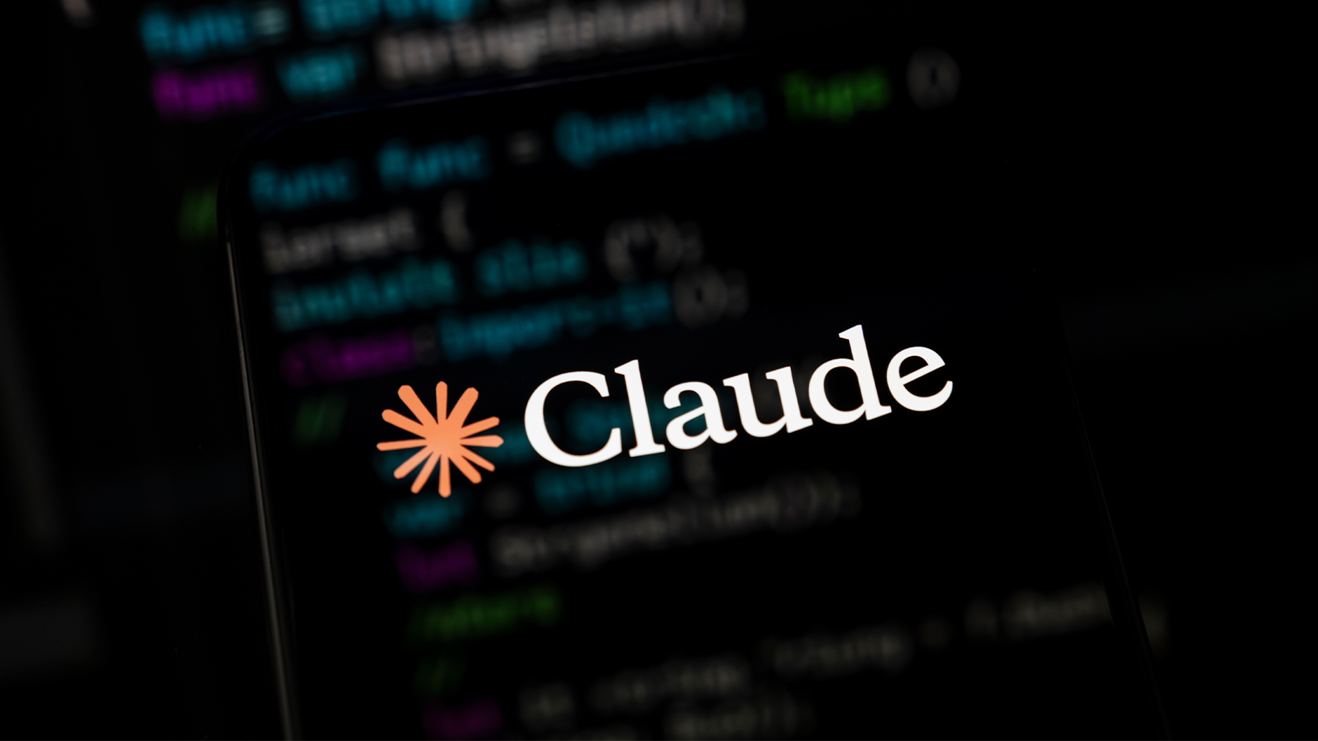 Logo of Anthropic's Claude AI tool imposed over computer source code.