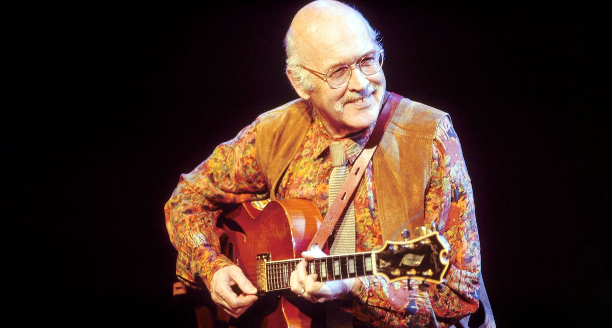 Jim Hall wears a brightly patterned shirt as he plays a jazz box onstage