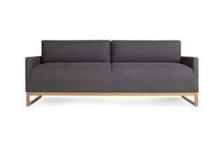 A dark gray sleeper sofa with wooden sleigh legs