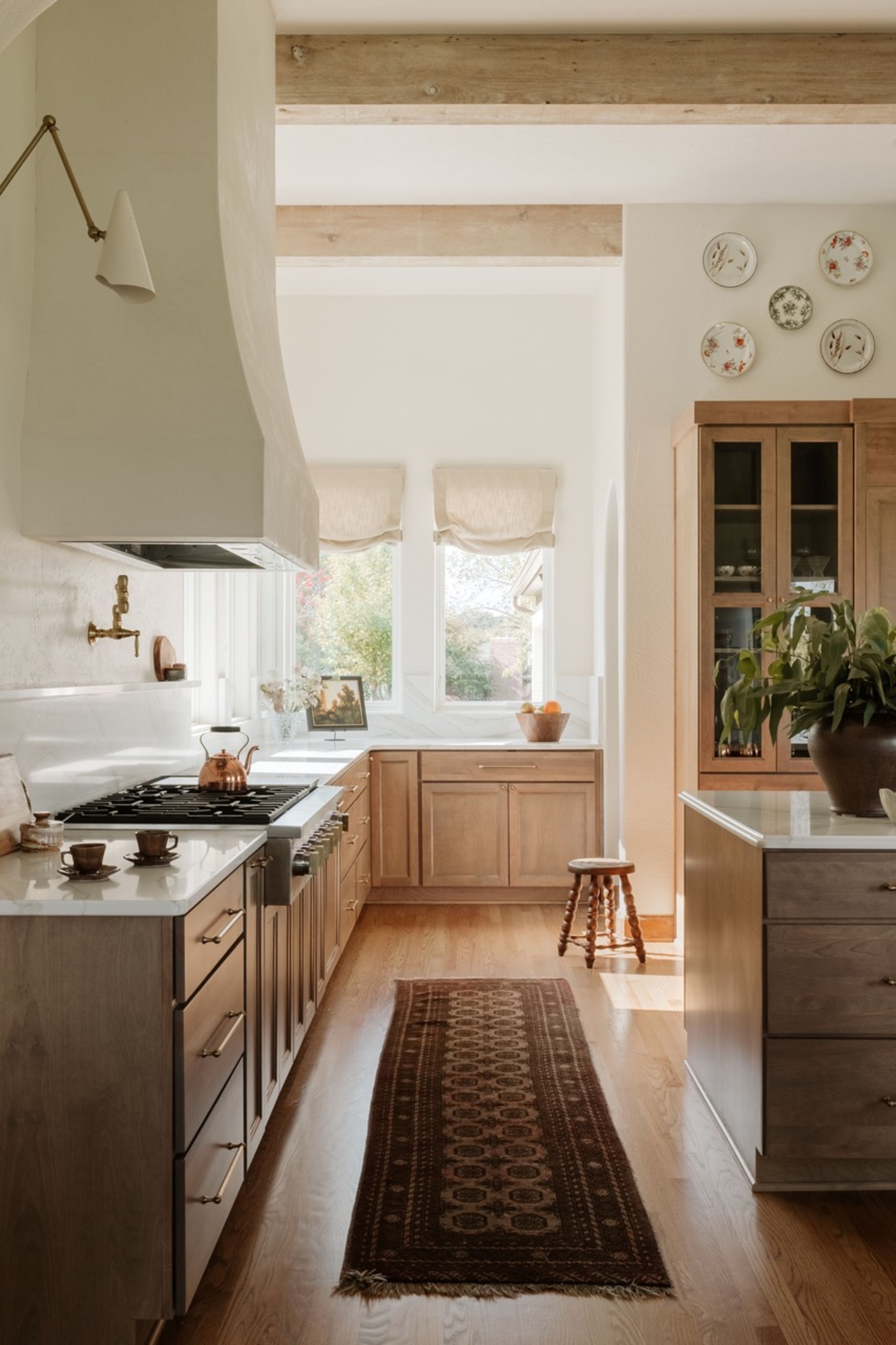 kitchen with roman blinds, timber cabinetry, plates on the wall, bobbin stool, and vintage runner