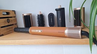 Dreame AirStyle Pro on shelf in reviewer's bathroom, with attachments lined up behind